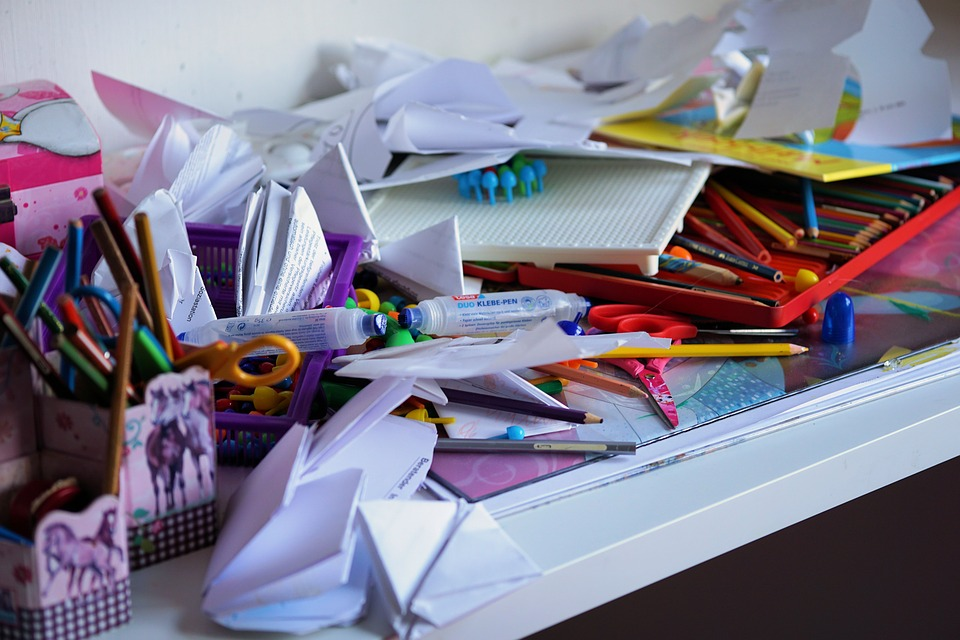 Desk cluttered with paper and pens in need of decluttering