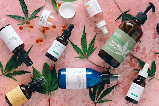 CBD bottles displayed on a pink background with marijuana leaves.